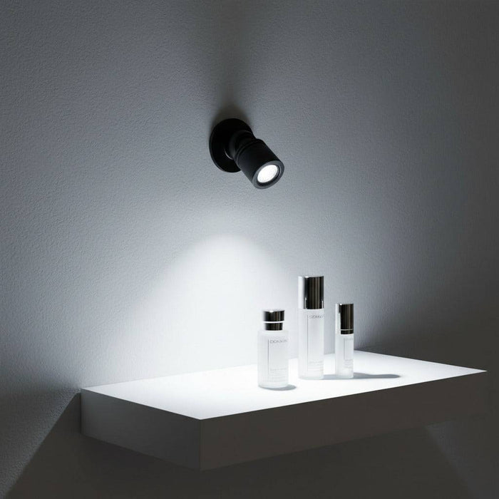 black LED spotlight for display cabinet installed on a wall over a cosmetics display