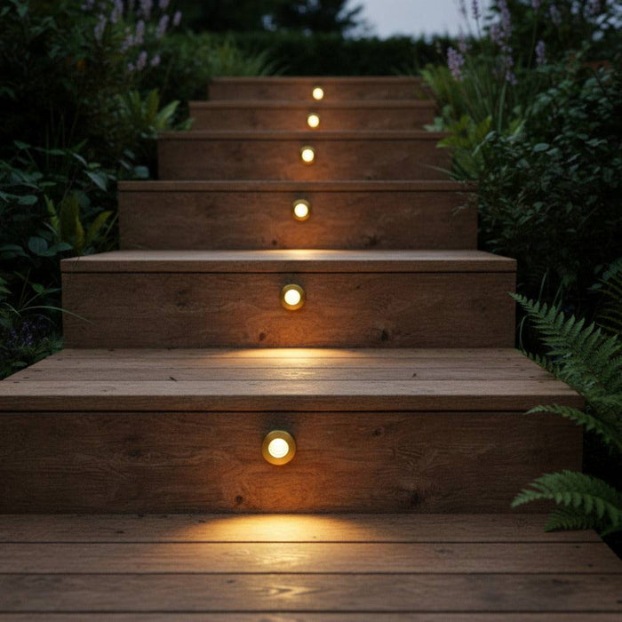 brass in ground decking light installed into wooden steps outdoors