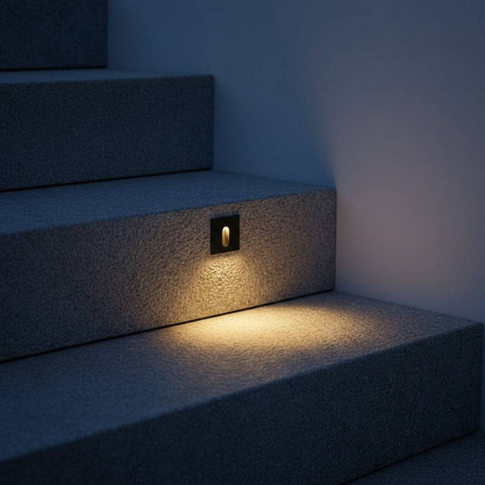black outdoor step light fixture mounted in a concrete outdoor step riser