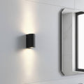 black bathroom wall mount light fitting shown on a wall next to a mirror in a bathroom