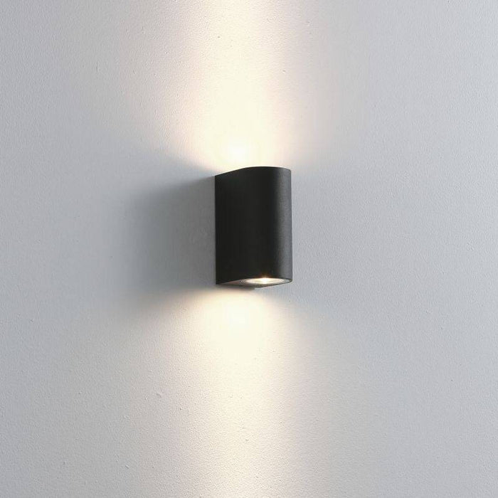 black outdoor up down light shown on a white wall