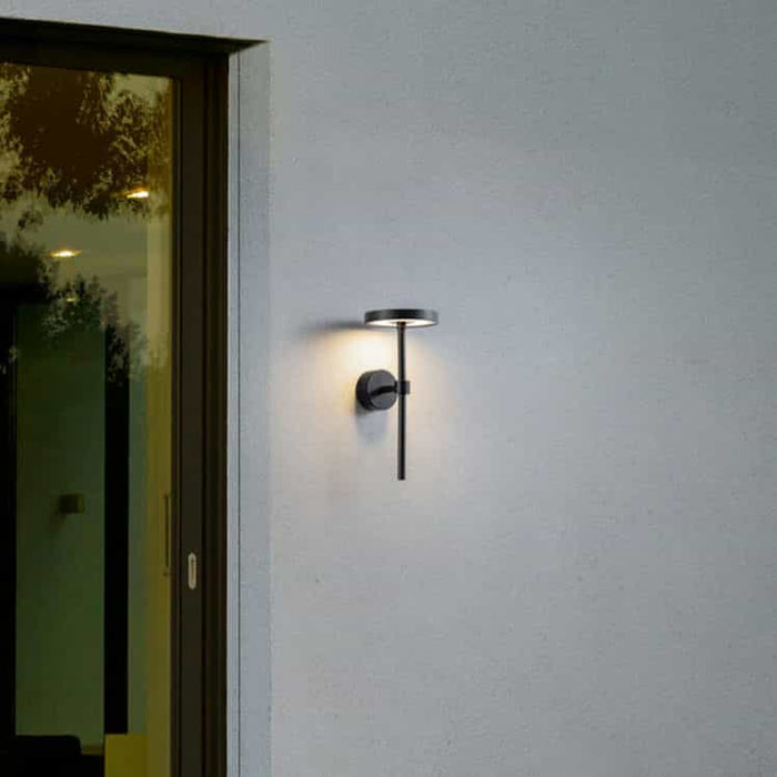 black contemporary external wall light installed on a white wall next to a door