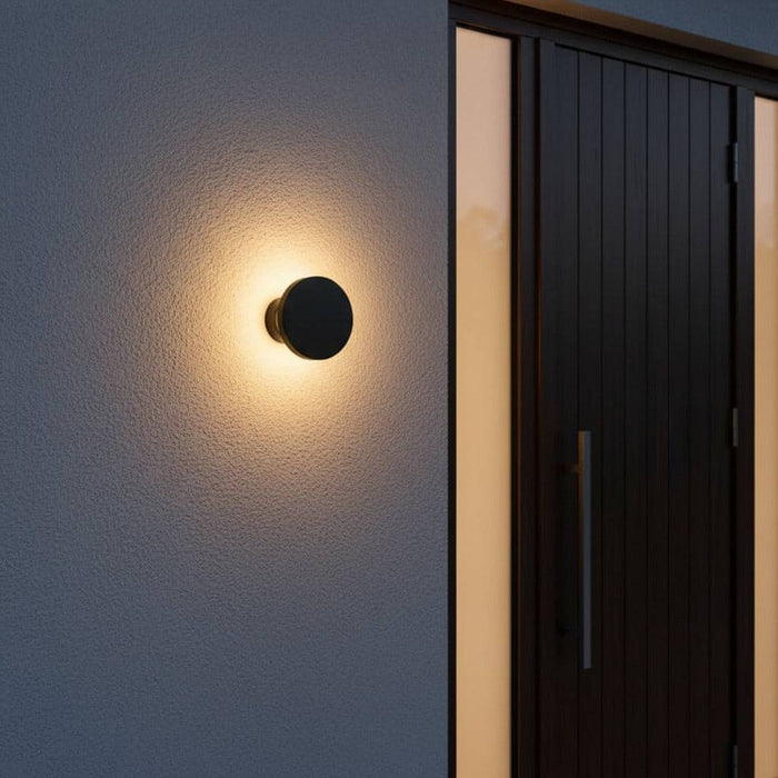 black exterior wall mount light fitted next to the entrance door of a modern home
