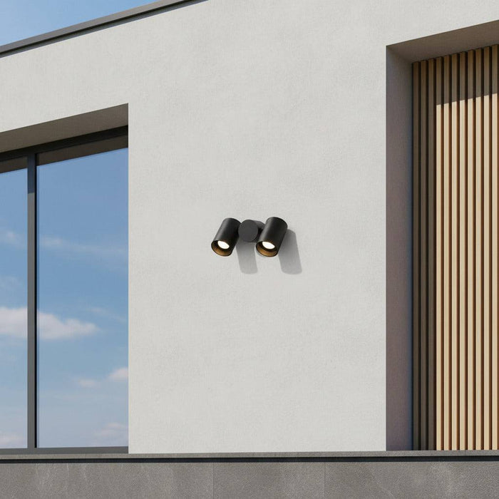 black outdoor wall spotlight mounted on the white wall of a contemporary home