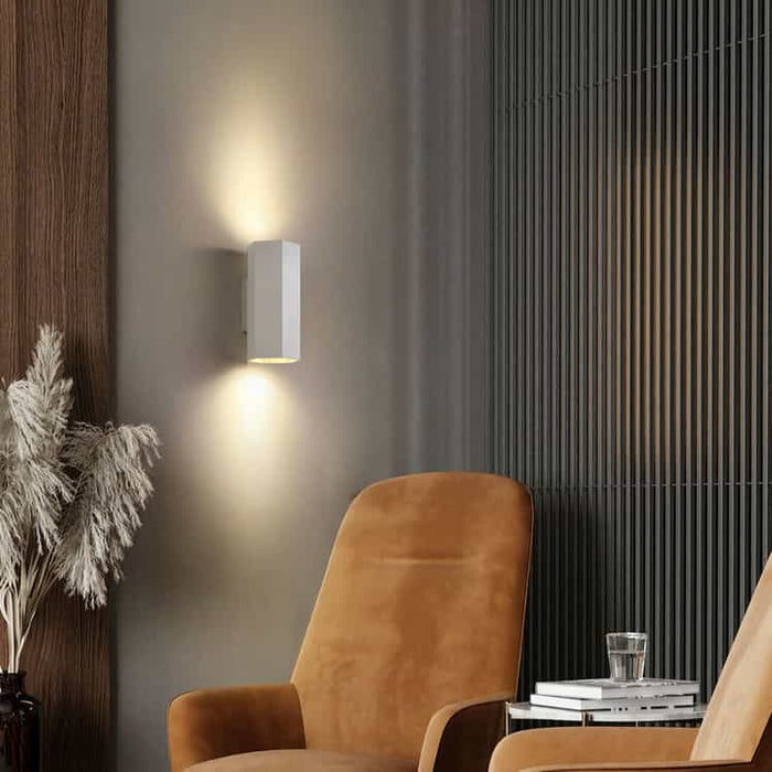 White interior up and down wall light on a grey wall in a lounge of a modern home