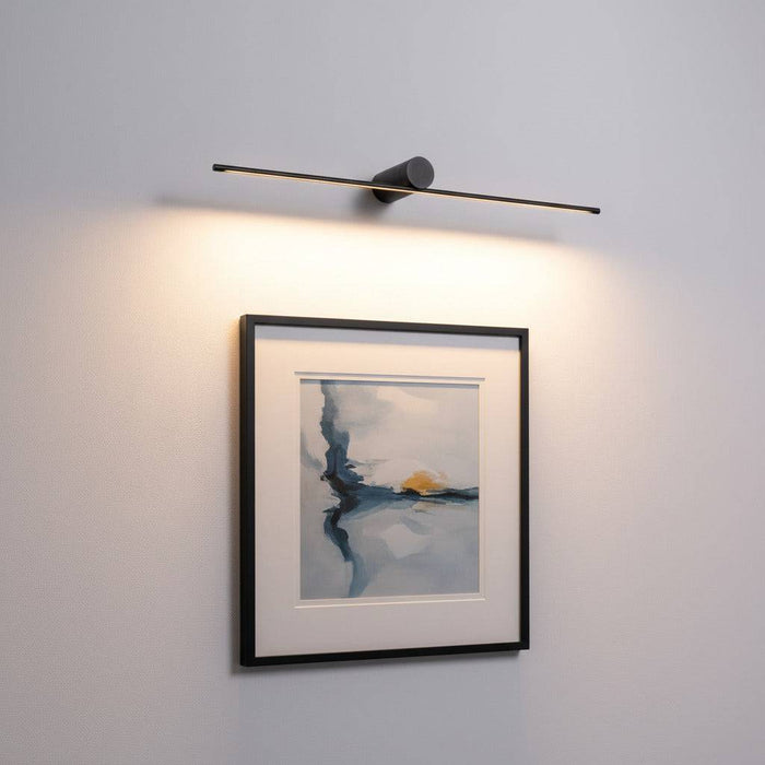black above picture light mounted on the wall over some artwork