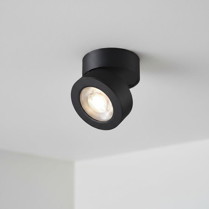 black adjustable ceiling lamp installed on a white ceiling in a house