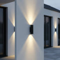 black outside up and down light mounted on a white column outside a modern house