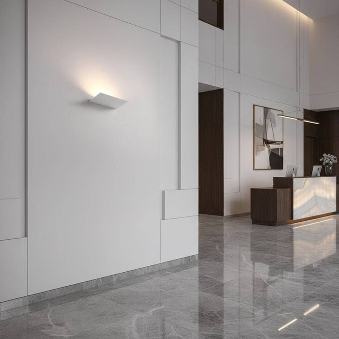 White indoor uplight wall light in the reception area of a hotel