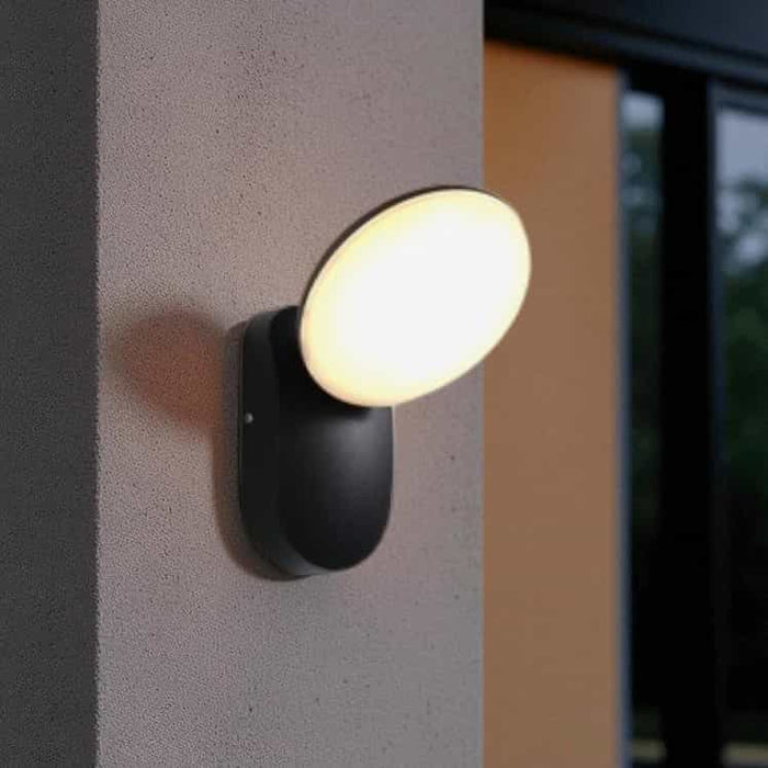 black outside house wall light mounted on a white textured wall outside a house