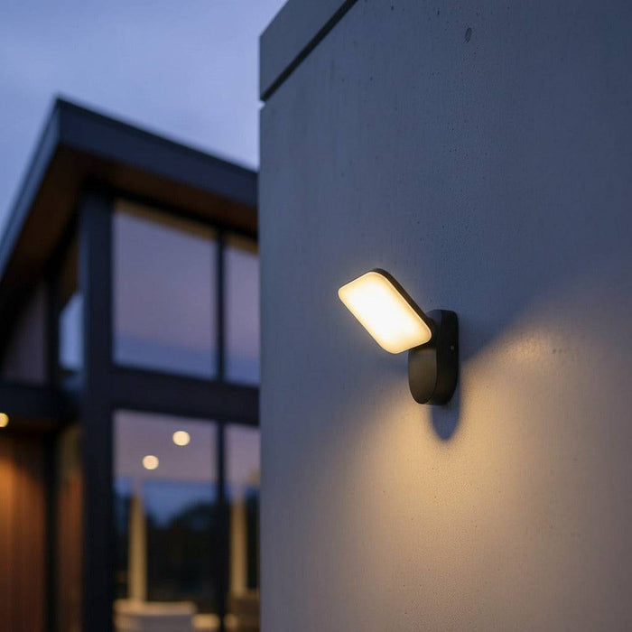 black external wall lamp mounted on a white wall outside of a modern home