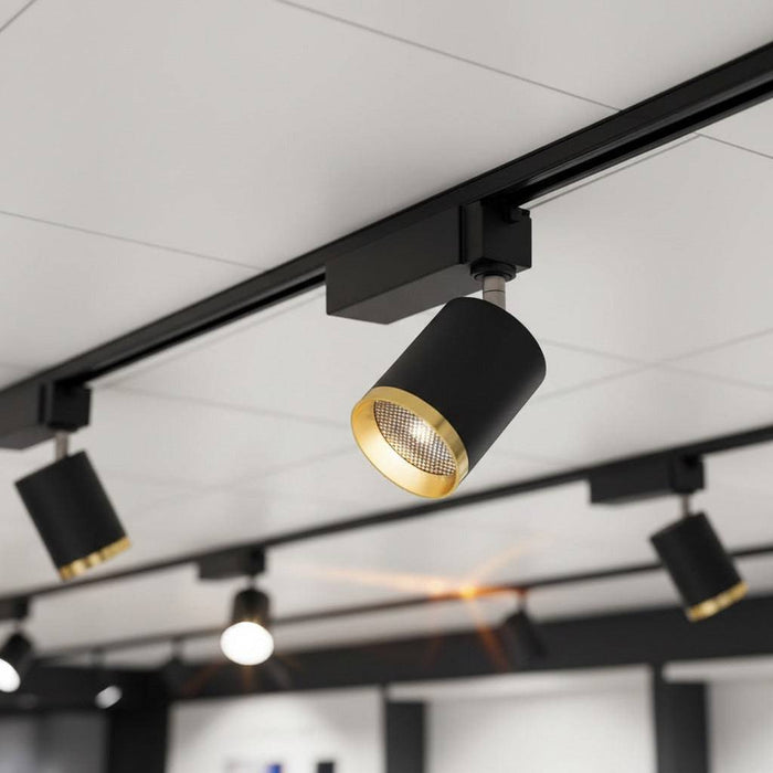 black and gold track spotlight installed on the ceiling of a retail store
