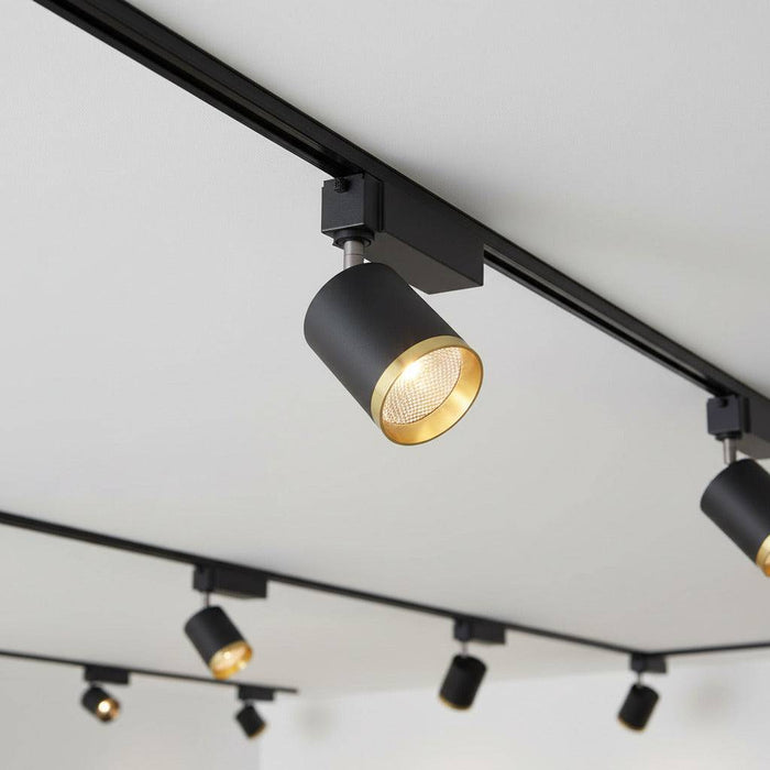 black and gold track spotlight mounted on a white ceiling