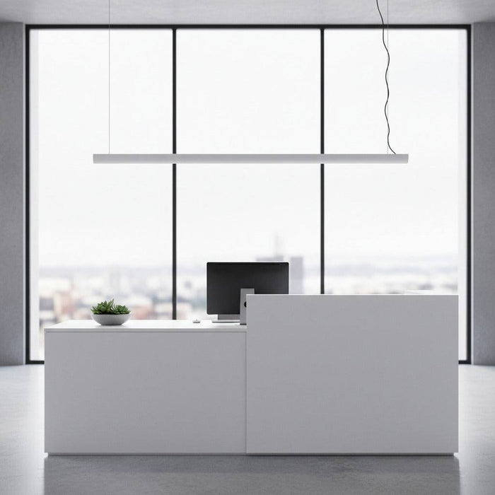 white linear bar pendant light installed over a reception desk