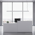 white linear bar pendant light installed over a reception desk