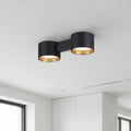 black flush fitting ceiling light installed on a white ceiling in a modern house