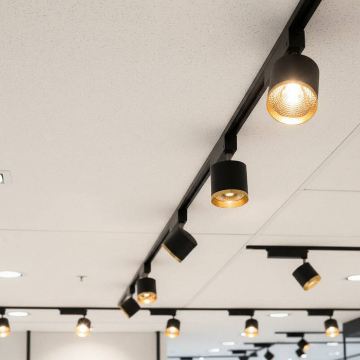 black and gold LED ceiling track spotlight mounted in a retail store