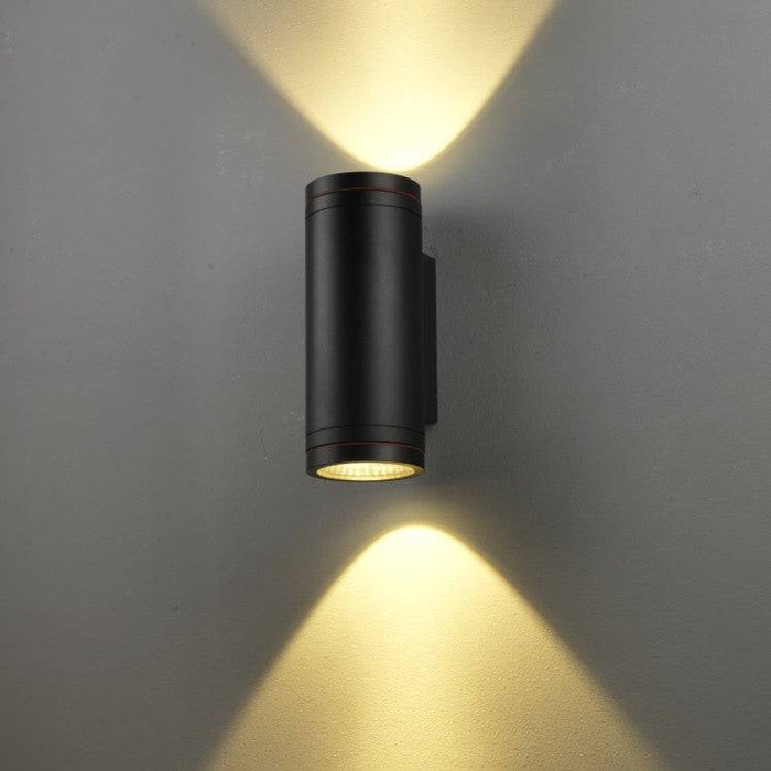 black large outdoor wall light shown mounted on a white wall