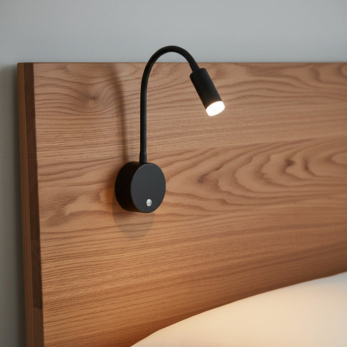black dimmable reading light for bed mounted on a wooden bed headboard