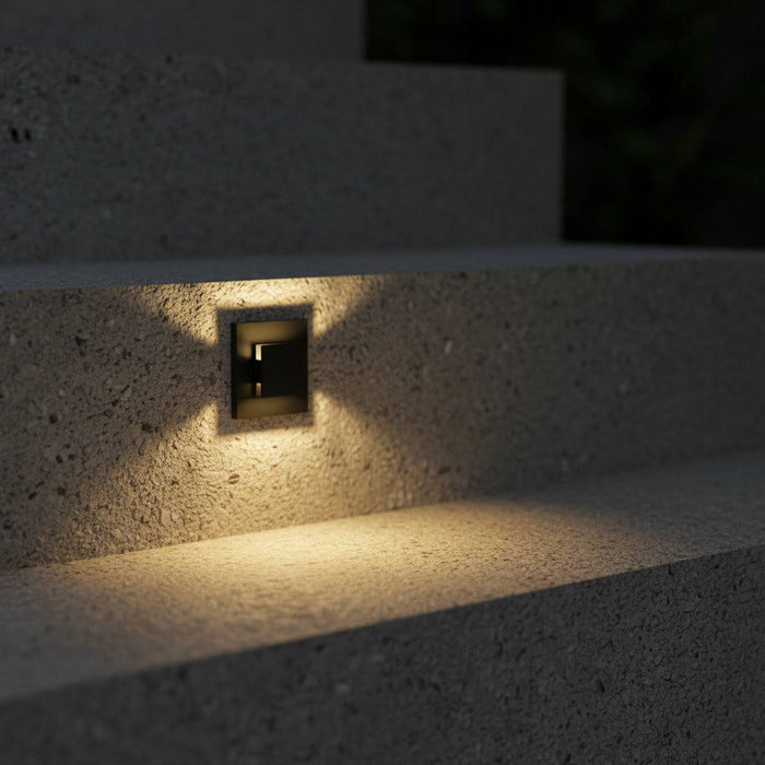 black recessed outdoor wall light mounted in a concrete step riser outdoors