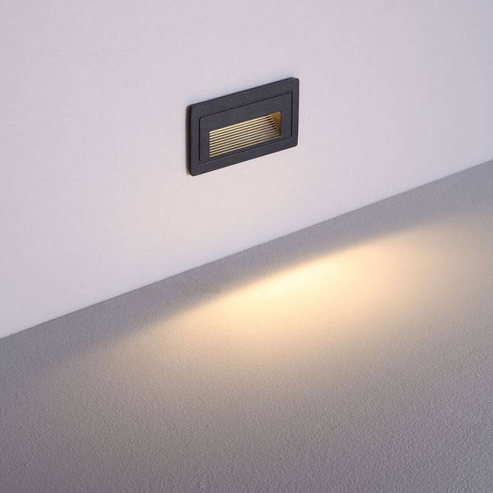 black low level wall light installed on a white wall