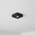 black slimline surface ceiling downlight mounted on a white ceiling