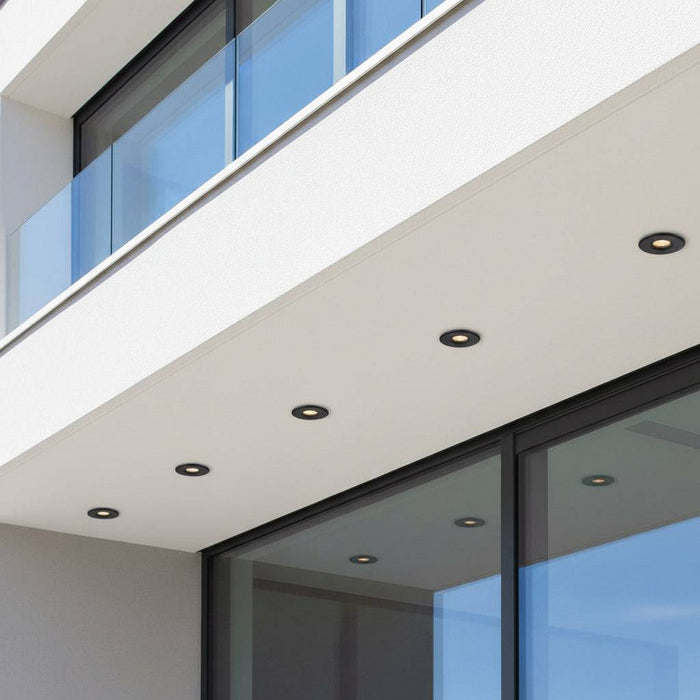 black small outdoor downlight mounted under roof of a modern home