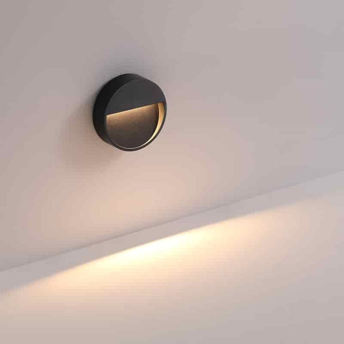 black external step light mounted on a white wall