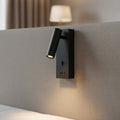 black wall mounted reading light with USB port mounted on a fabric headboard