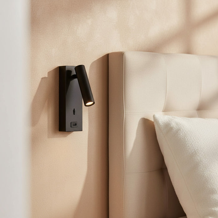 black wall mounted light with USB port mounted on the wall next to a bed