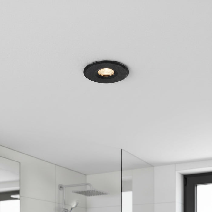 black waterproof recessed bathroom ceiling light installed on the ceiling in a bathroom