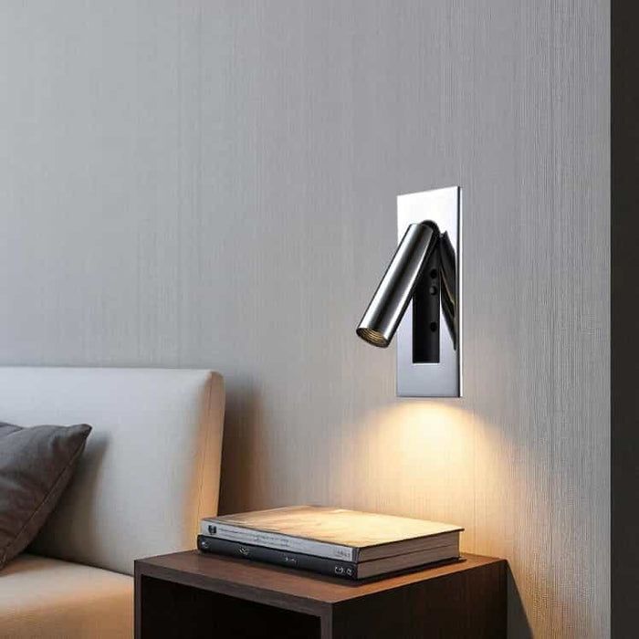 Polished chrome recessed LED reading wall lamp mounted next to a bed over a bedside table