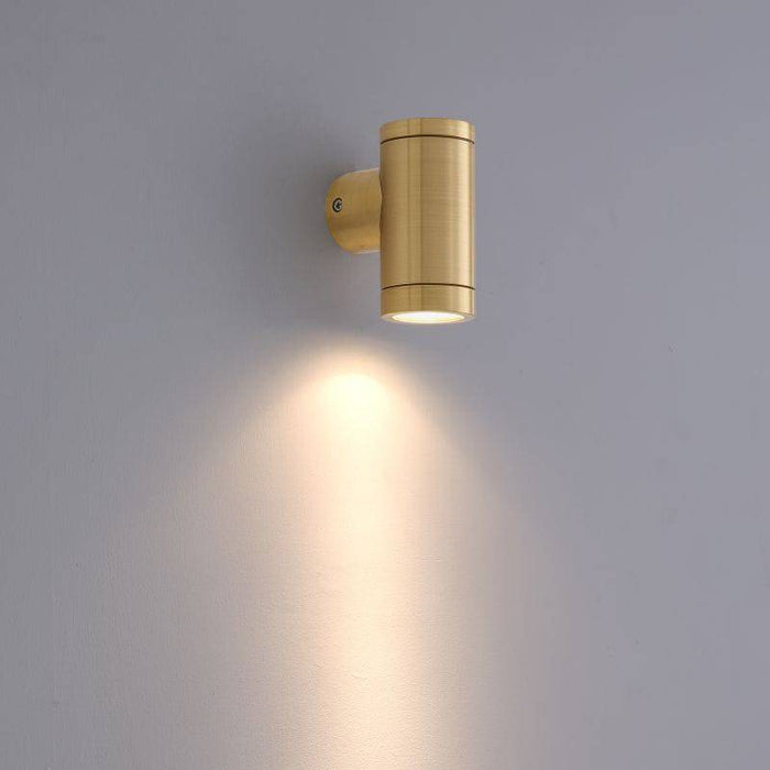 exterior brass wall light mounted on a white wall