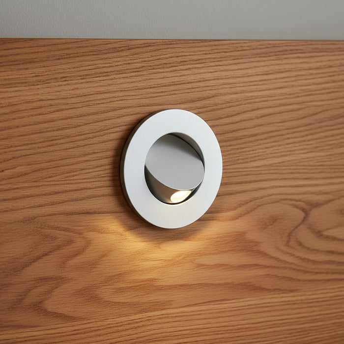 silver recessed wall or bed headboard reading light mouonted on a wooden headboard
