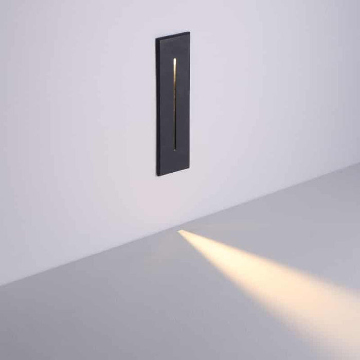 black flush mounted exterior wall light mounted on a white wall