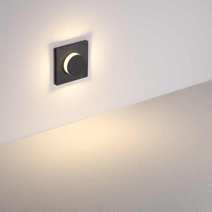 black flush mount sconce light shown mounted on a white wall