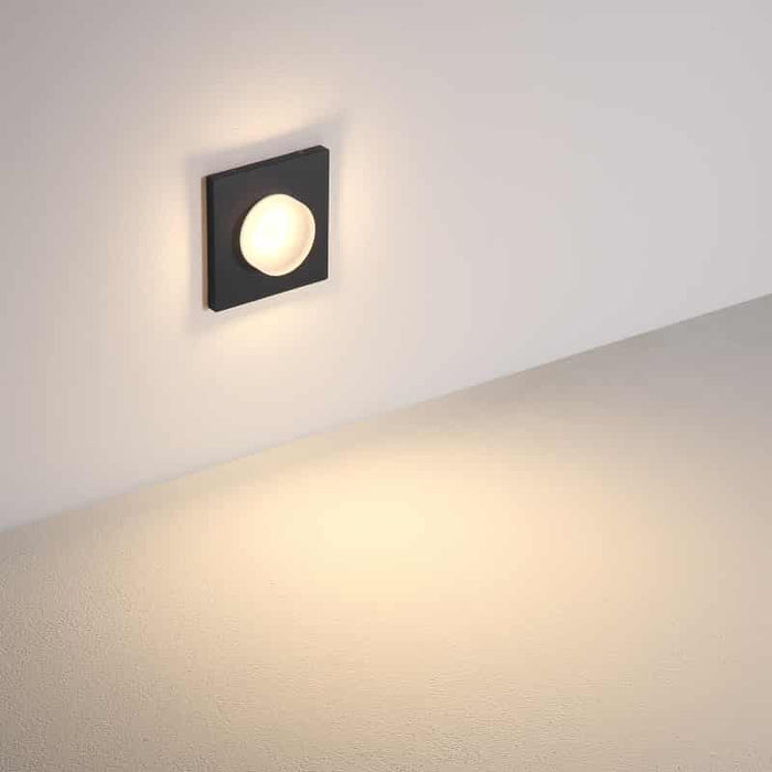 black outdoor step light mounted on a white wall