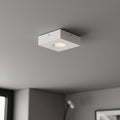 white low profile surface mount downlight installed on a grey ceiling