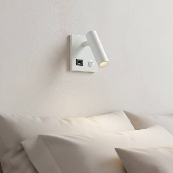 white recessed bedside reading lamp with USB port mounted over a bed on the wall in a modern bedroom