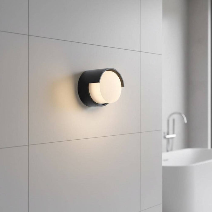 black bathroom wall light fixture mounted on a tiled wall in a modern bathroom
