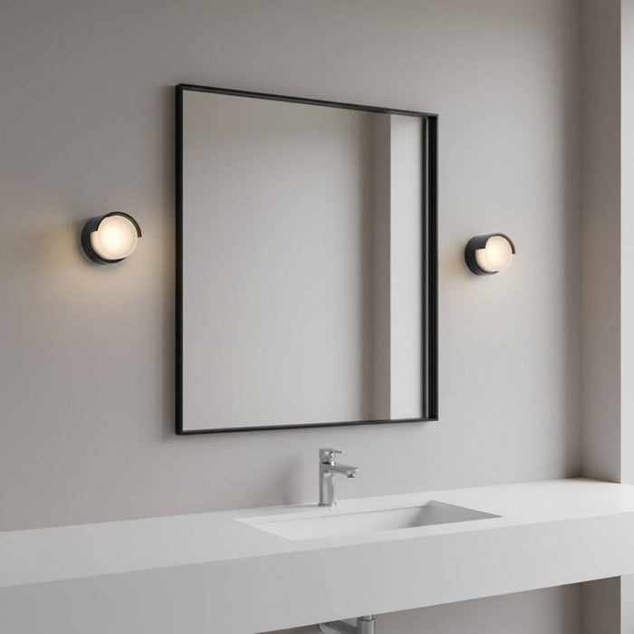 black bathroom wall light fixture mounted either side of a mirror in a modern bathroom
