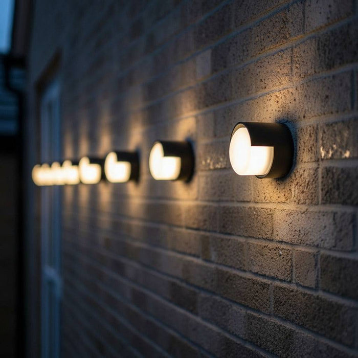 black outside wall lamp mounted in a line along the brick wall of a modern home