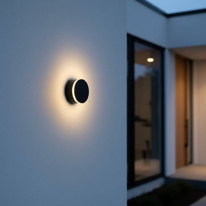 black wall outdoor lamp mounted on a white wall outside of a modern home