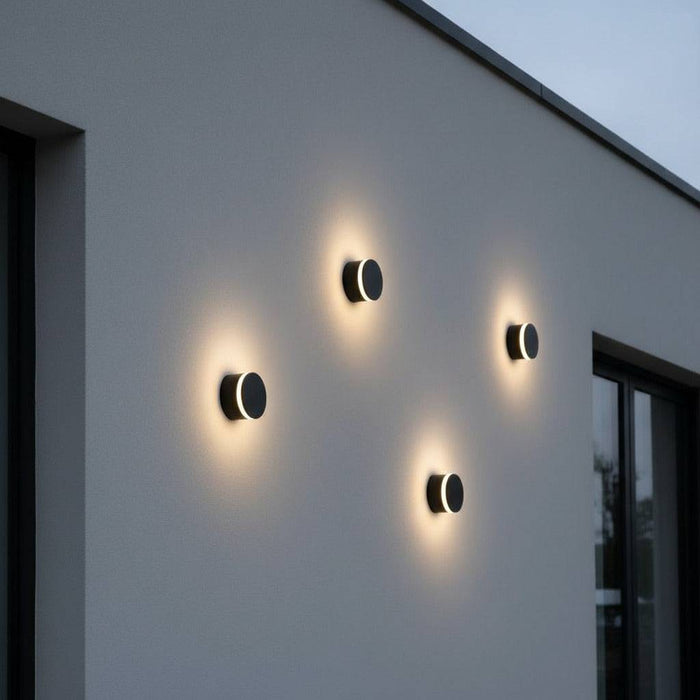 black wall outdoor lamp with 4 lights mounted on the white exterior wall of a modern house
