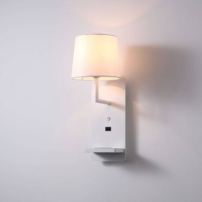 White reading wall lamp for the bedroom mounted on a plain white wall