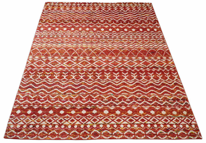 Hand-knotted silk area rug featuring rust, gold, and white striped trellis pattern