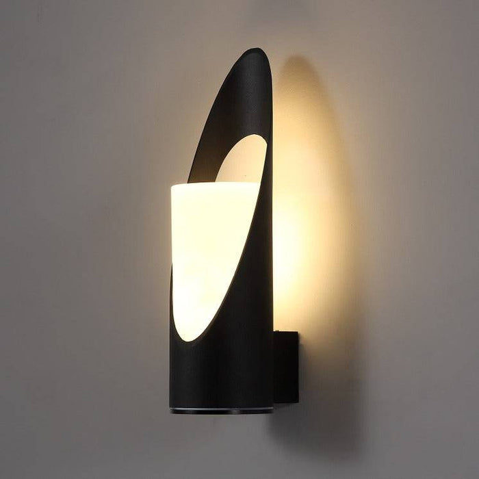 black outdoor wall light shown mounted on a white wall