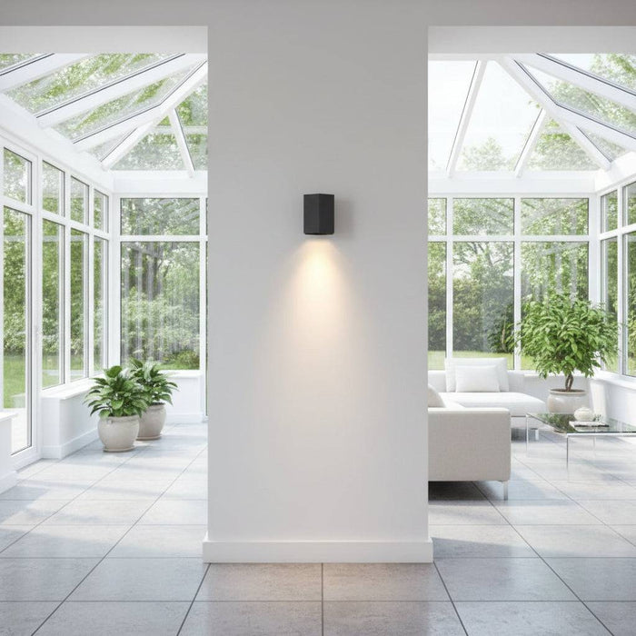 Black interior LED wall downlight in a modern conservatory looking towards the garden