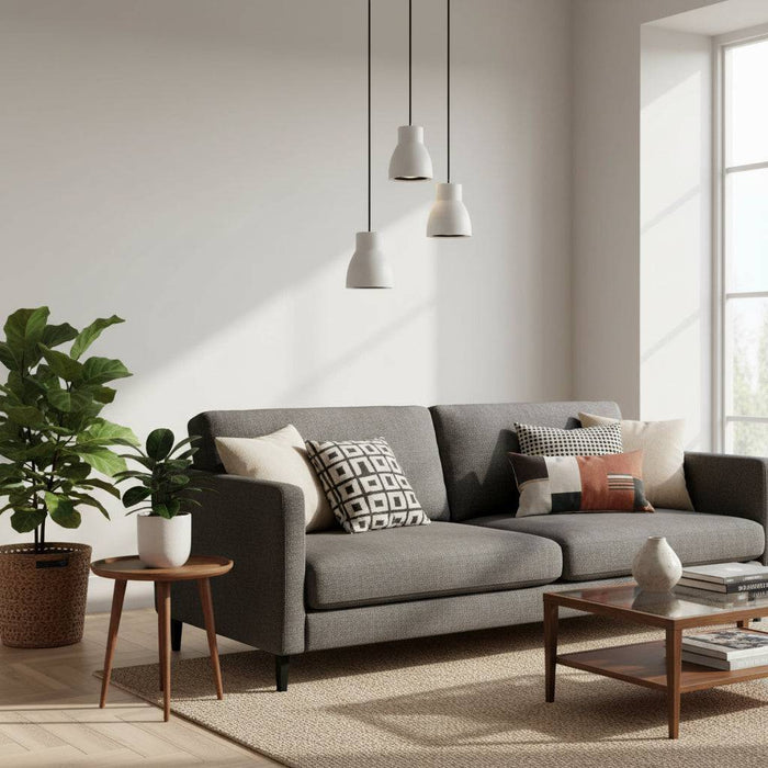 White pendant light fixture three lights over a sofa in a lounge with plants