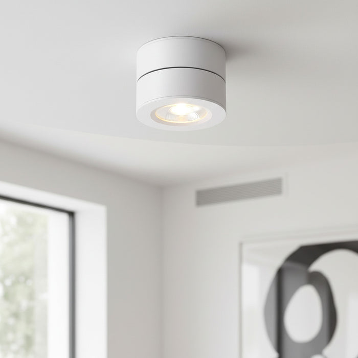 white adjustable ceiling light mounted on a white ceiling in a living room